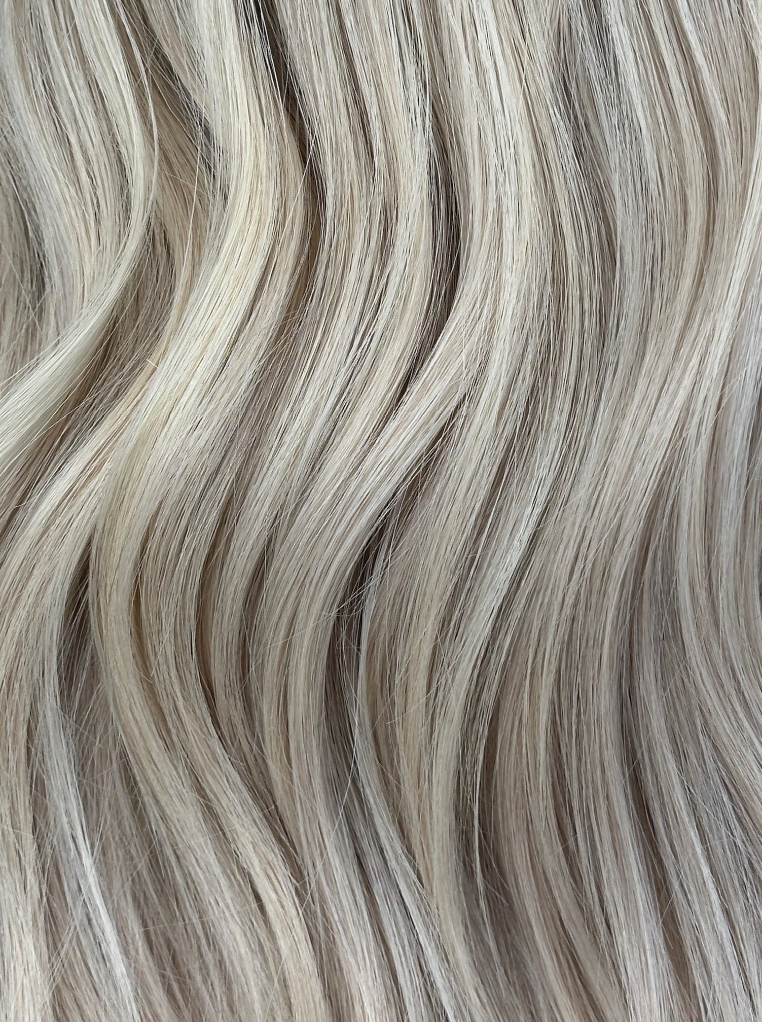 A close-up image of bright blonde wig with Platinum highlights showing a variety of shades and lengths.