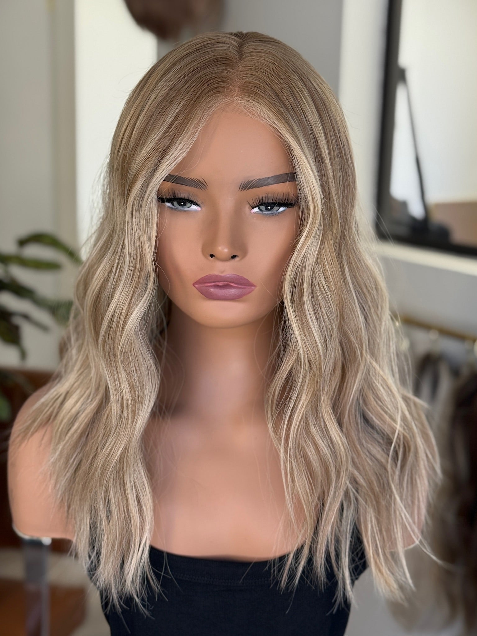 RootedBlonde wig on a mannequin head with a neutral background