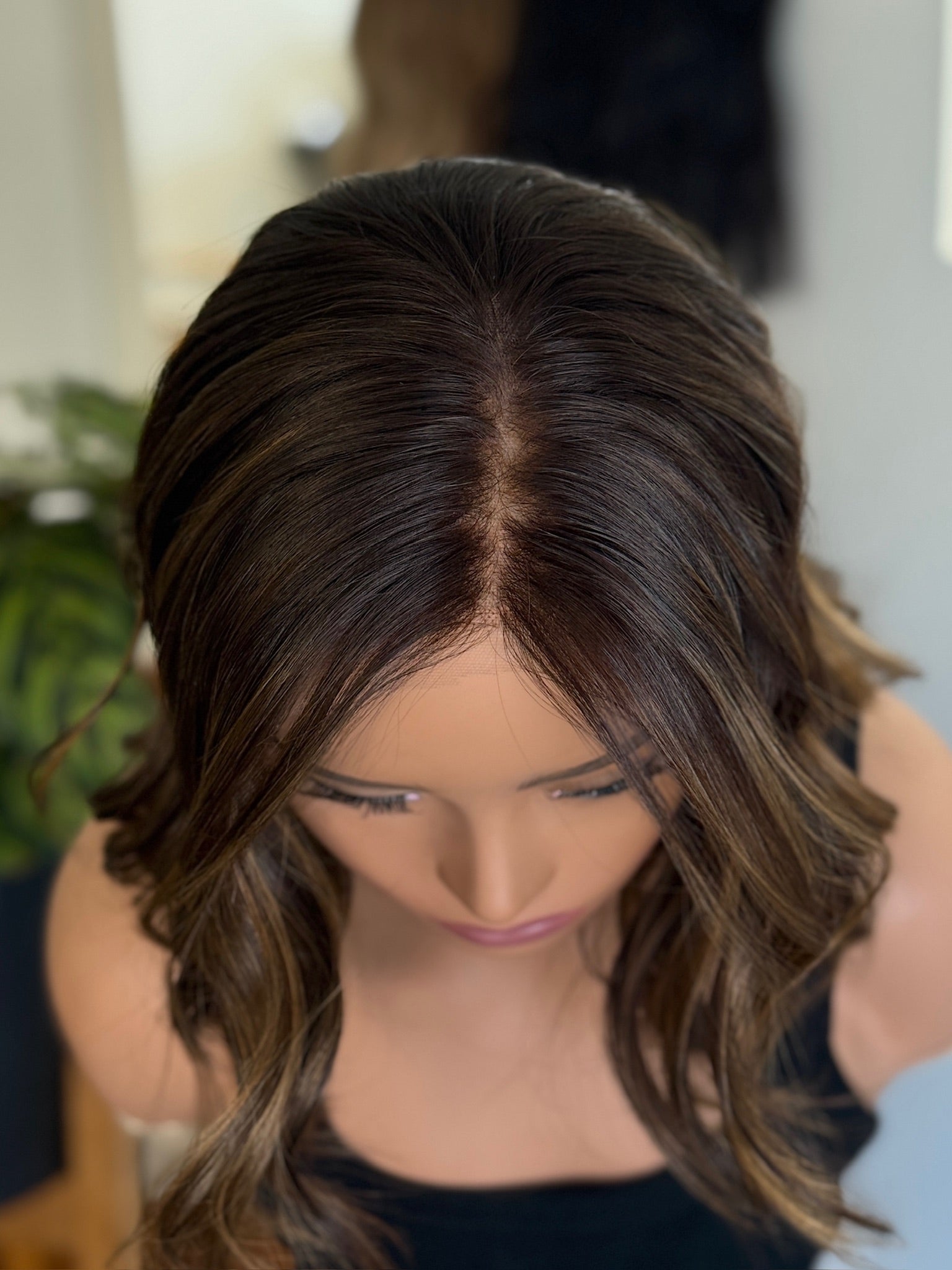 Mannequin head with brown wig styled in a shoulder-length cut.