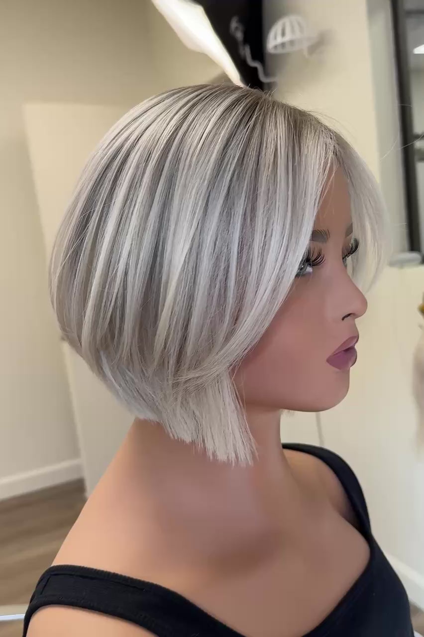 Video demonstration of a shoulder-length wavy blonde wig on a mannequin in a brightly lit wig shop, showcasing the hair from various angles to highlight the waves, volume, and natural look.